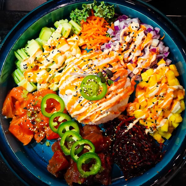 A vibrant MISO Ramen and Poke Bar poke bowl with various toppings and sauces.